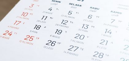 Blurred view and selective focus of Javanese Indonesian calender page of holiday date of the month exposed by side lighting.