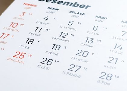 Blurred view and selective focus of Javanese Indonesian calender page of holiday date of the month exposed by side lighting.